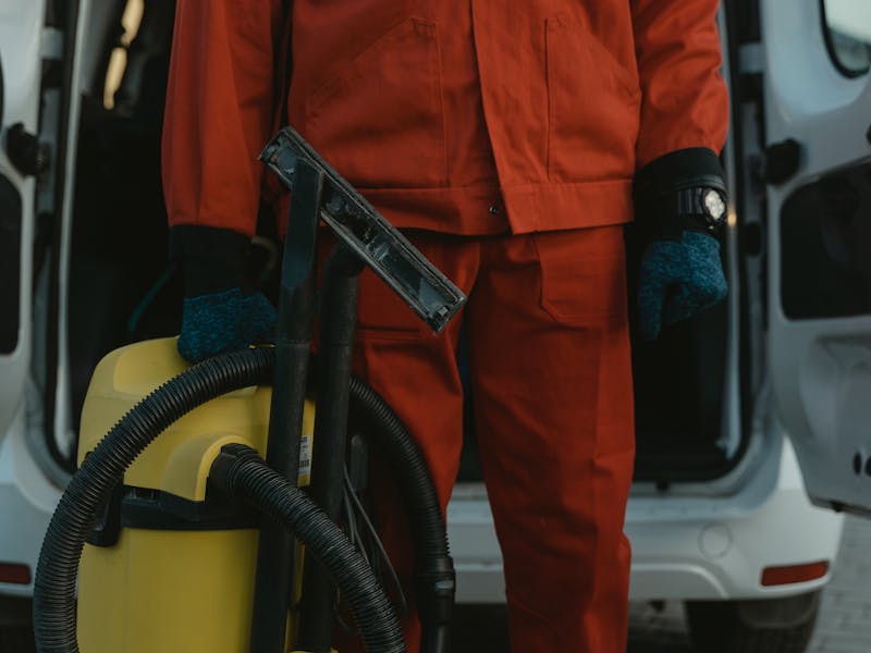 Professional cleaner with vacuum at a commercial facility