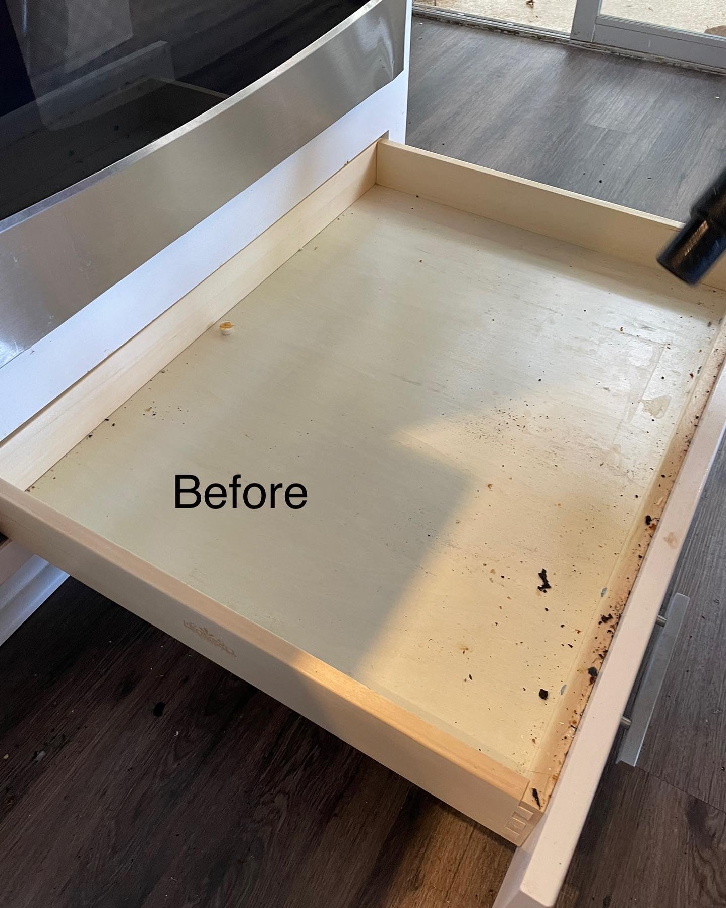 Pull-out cabinet shelf before cleaning — debris and buildup